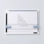 Top view of a white drawing board with a horizontal clear ruler, triangle guide and edge clips