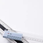 Close-up of a pale blue ruler control with direction arrows beside a graduated transparent guide