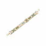 Green and tan geometric bag strap laid diagonally with clips at both ends and a sliding adjuster