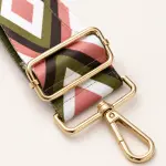 Close-up of a gold-tone slider and snap clip on a pink, olive and white patterned strap