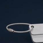 Close-up of the luggage tag cable passing through its corner hole beside the screw connector