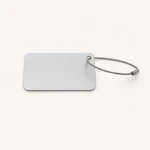 Plain reverse side of a silver luggage tag with its cable loop extended to the right