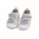 Par de zapatos de malla con ribetes beige sobre blanco, vista frontal oblicua