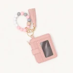 Pale-pink beaded loop, tassel and matching card holder in a flat lay
