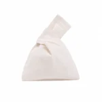 Natural cotton knot wristlet bag upright on white
