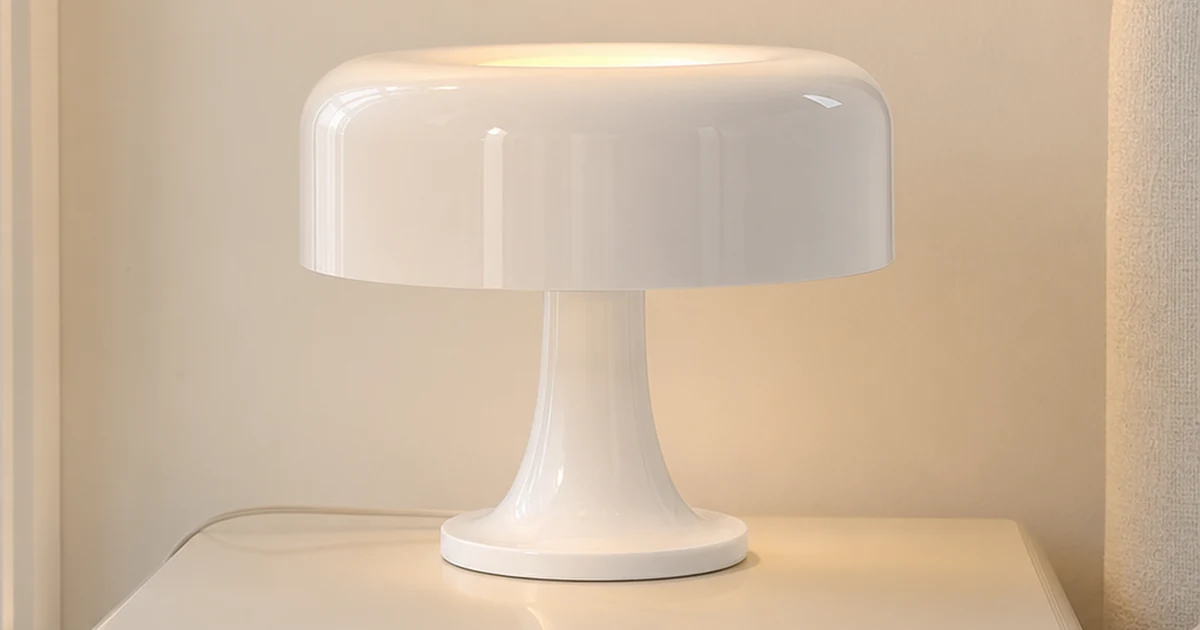 Luminária cogumelo branca na mesa de cabeceira com o cabo de alimentação visível.