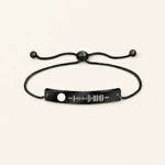 Black engraved bar bracelet arranged in an oval on a light background