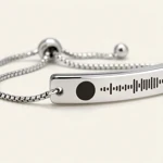 Close view of the silver engraved curved bar and its chain connection