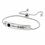 Silver curved-bar bracelet at an angle with sliding bead and ball-ended tails