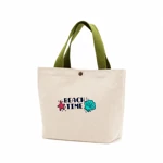 Green-handled canvas tote with shell and starfish print on white