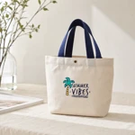 Blue-handled palm-print canvas tote on a neutral table