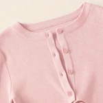 Close-up of the pink top's round neckline, five-button front and vertical ribbed texture