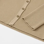 Close-up of the beige cardigan's ribbed hem and sleeve cuff edges