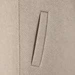 Close view of a slanted welt pocket and the woven herringbone pattern