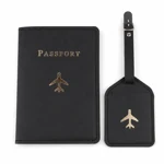 Étui à passeport noir cousu près d'une étiquette de bagage avion avec sangle à boucle