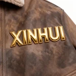 Close-up of gold XINHUI lettering on the mottled brown chest