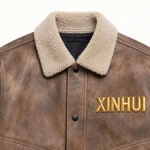 Cream plush turn-down collar and black snap on a brown jacket