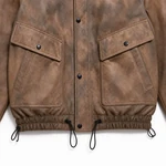 Two large brown flap pockets above the gathered drawstring hem