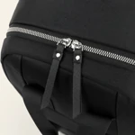 Detalle de dientes plateados de cremallera y dos tiradores negros largos