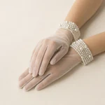Hands wearing full-finger sheer gloves with wide beaded wrist cuffs