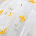 Close-up of floral embroidery on the mesh layer of the ballet wrap skirt