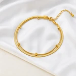 Gold anklet displayed on soft ivory fabric