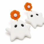 Close view of orange flower stud, gold link and white ghost charm