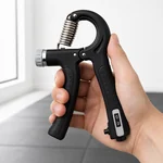 Black gripper held in one hand during grip exercise