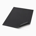Black puff HTV sheet with a lifted corner showing the clear carrier layer, on white.