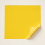 Yellow puff HTV sheet with a gently lifted corner showing its clear carrier, on a light background.
