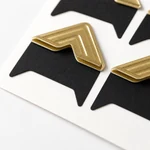 Close view of four folded gold paper corner pockets