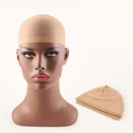 Bonnet beige sur mannequin près d’un second bonnet plié