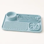 Vista laterale obliqua di un tappetino in silicone azzurro con ciotola rotonda rialzata e quattro aree sagomate distinte