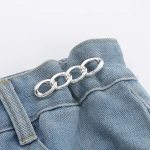 Silver: four oval metal links on blue jeans