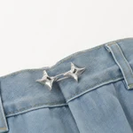 Silver star fastener joining a jeans waistband