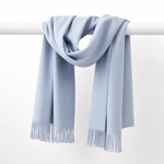 Una sciarpa grigio azzurro chiaro drappeggiata su una barra orizzontale