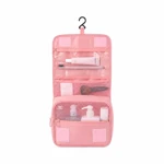 Pink hanging bag opened to show clear and mesh zip sections with sample travel items