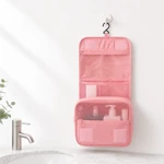 Pink organizer hanging open above a bathroom basin with its metal hook visible