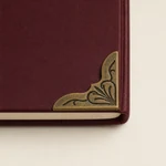 Corner fitting on burgundy notebook