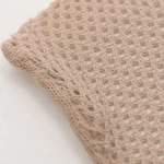 Primer plano de las aberturas de malla beige y el borde cosido