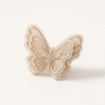 Coffee-colored embroidered organza butterfly displayed alone on a warm ivory background.