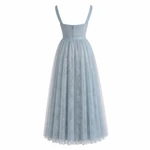 Rear view of the blue dress showing two straps, a plain matching waistband, center-back seam, and gathered skirt.