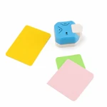 Perforatrice d'angles bleue à côté de cartes jaunes, vertes et roses aux coins arrondis