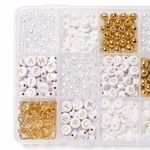 Vue de dessus des compartiments avec perles blanches à lettres dorées, perles rondes et fermoirs dorés