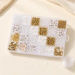 Boîte compartimentée pour perles sur une table claire, avec une bobine de fil transparent à côté