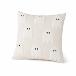 Cream cushion cover with large raised white ghosts on a clean white background