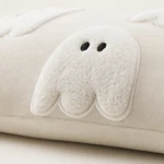Close-up of white ghost embroidery with two black eyes and stitched edges
