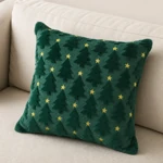 Green Christmas-tree cushion with gold stars on a beige sofa