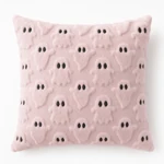 Front view of a pink cushion with raised ghost motifs