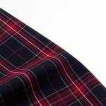 Red lines crossing dark plaid fabric in a draped fold